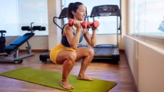 woman does a dumbbell squat